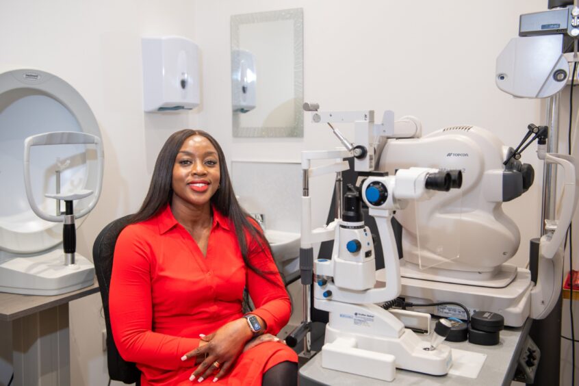 Christy sitting next to optical equipment 