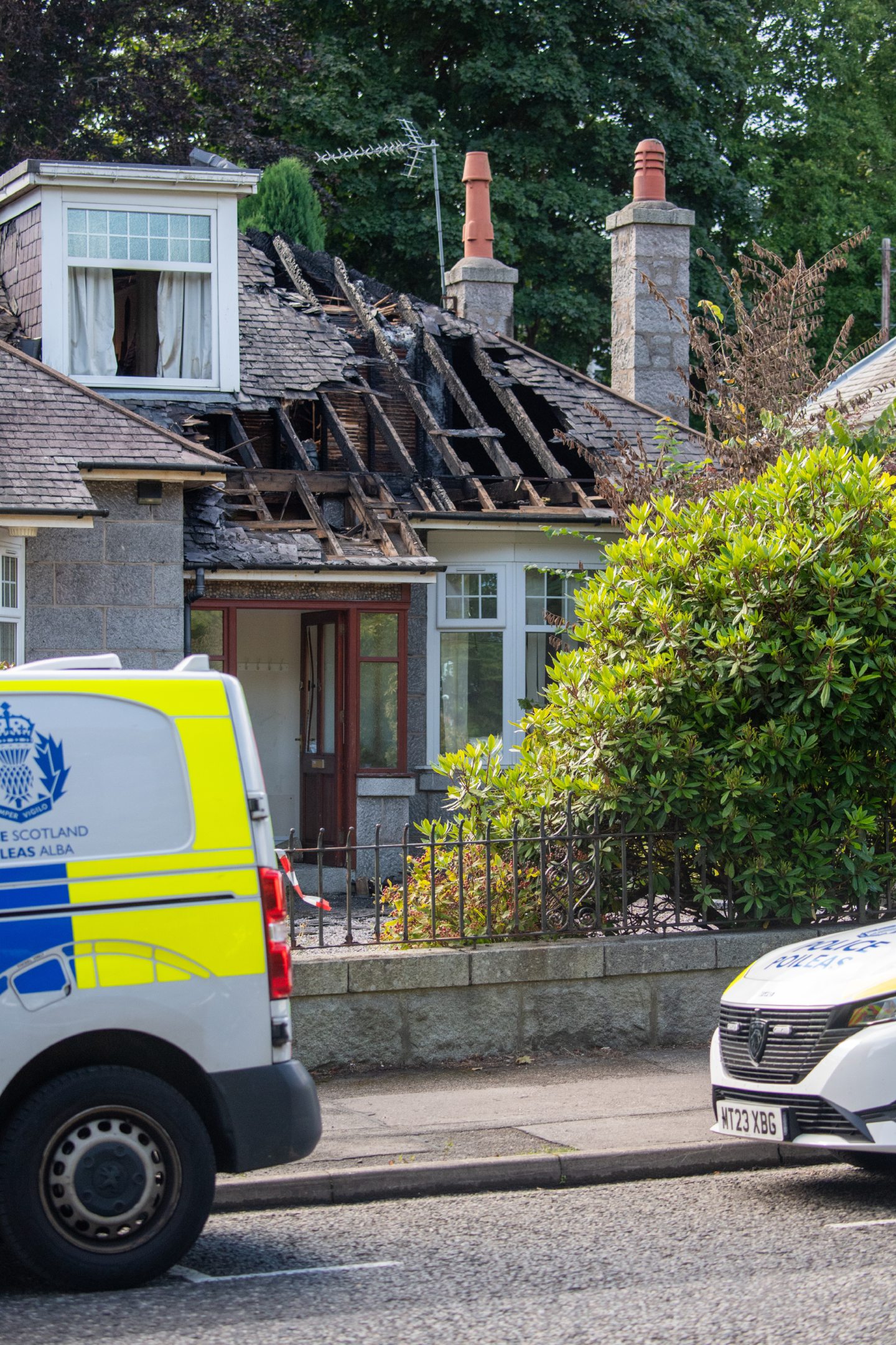 Police remain at the scene of a house fire in Westburn Drive. 