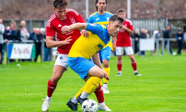 Strathspey's James McShane under pressure from Deveronvale's Oleg Dlugosz. Image: Kami Thomson/DC Thomson.