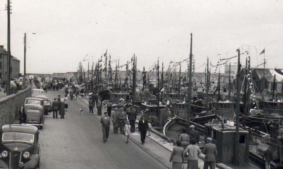 Old photo of Lossiemouth harbour full of fishing boats. 