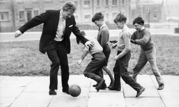 Denis Law, the most expensive footballer in Britain at the time,  pictured playing football with some youngsters on 16 March 1960 in Woodside, Aberdeen. 
Image: Aberdeen Journals.