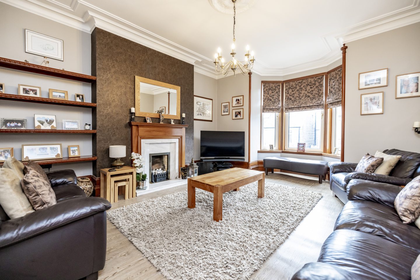 The lounge in the Aberdeen West End apartment, including a bay window and a fireplace.