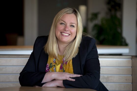 Louise Lang wearing a black jacket and yellow top.