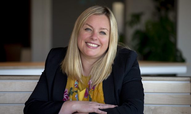 Louise Lang wearing a black jacket and yellow top.