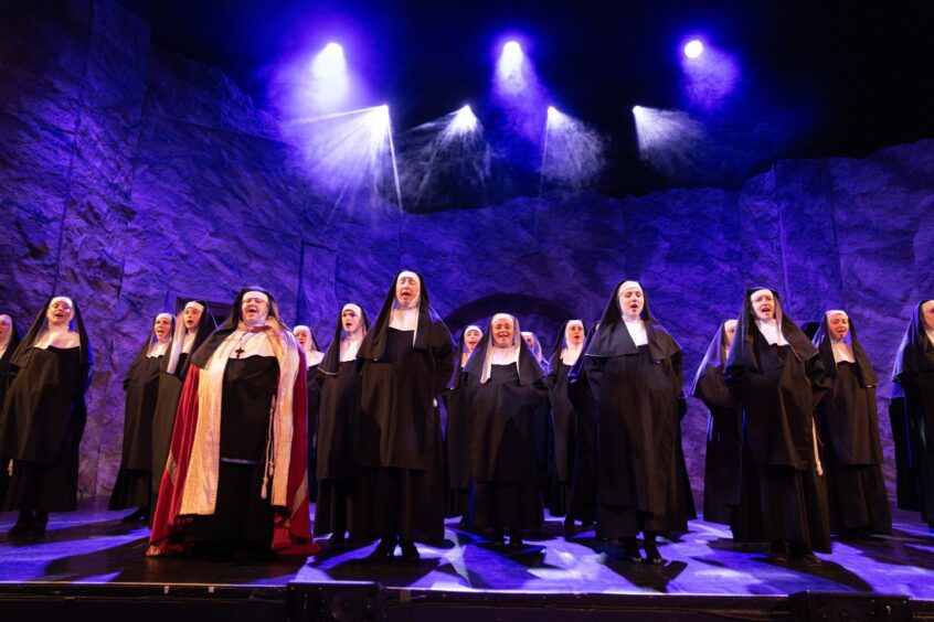 Around two dozen nuns singing on stage in the show.