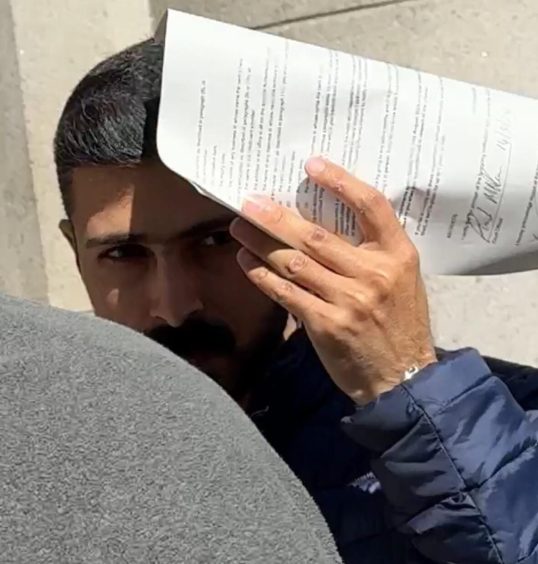 Mehrdad Esmaeili tried to hide as he left Aberdeen Sheriff Court 