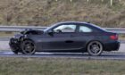 The black BMW, which was allegedly driven by Gavin Coull, sits at the side of the A90. Image: Newsline Media