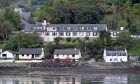 Portree Community Hospital surrounded by houses along the waterfront.