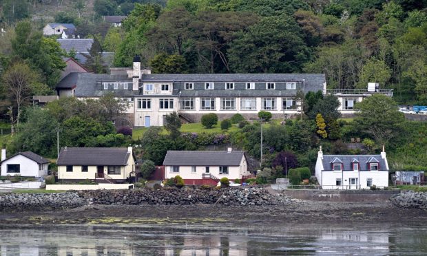 Portree Community Hospital surrounded by houses along the waterfront.