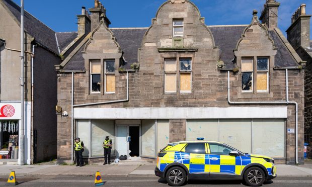 Officers outside empty building in Buckie