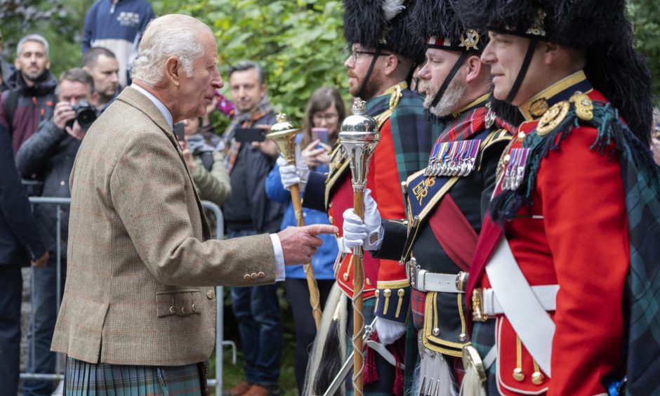 King Charles III meets members of the Band of The Royal Regiment of Scotland and the Pipes and Drums of the Royal Corps of Signals.