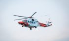 Red and white coastguard helicopter in the Skye.