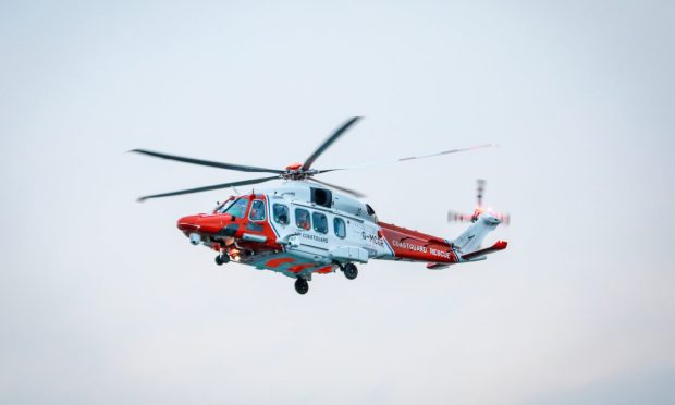 Red and white coastguard helicopter in the Skye.