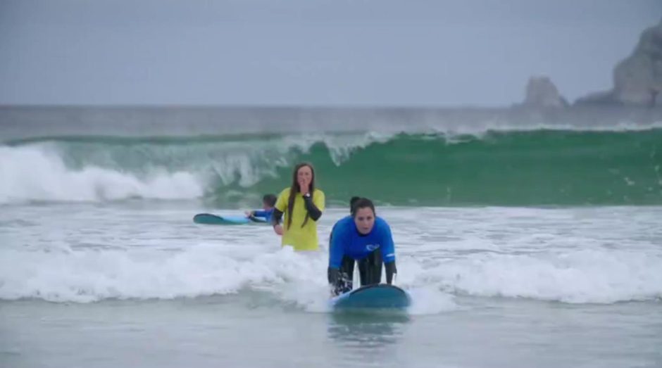 Iona in the water with a female surfer in front of her. 