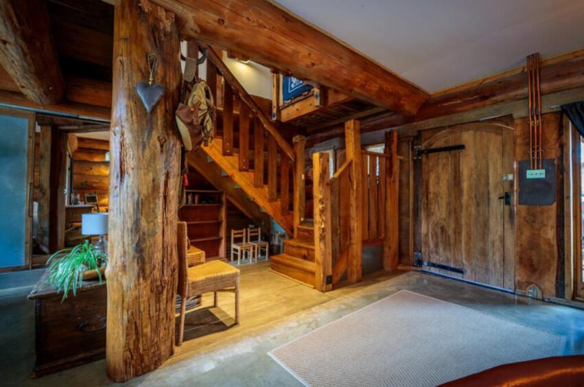 Wooden staircase in a home made from wooden logs.