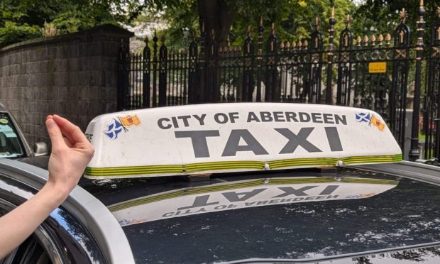 A signer using the BSL sign for "taxi" at Aberdeen Back Wynd taxi rank. Image: Alastair Gossip/DC Thomson