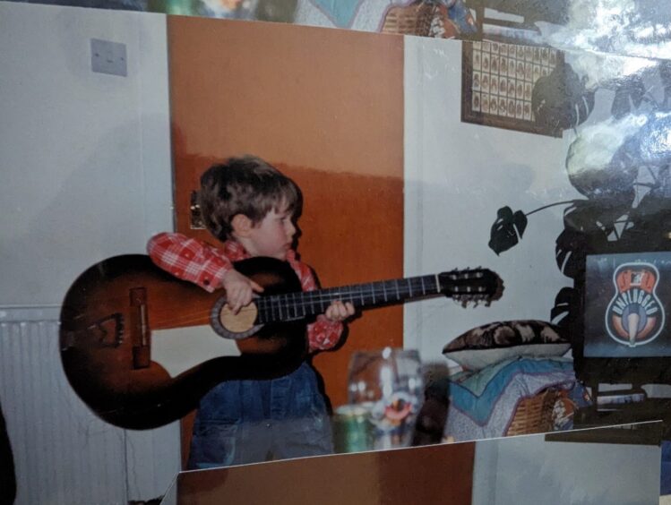 Don as a child holding his guitar