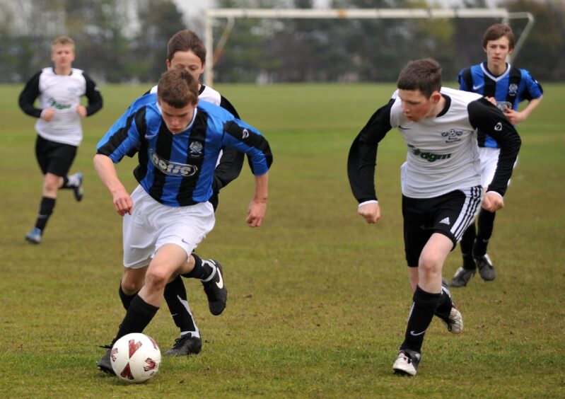 A Bridge of Don player makes a break away from chasing Byron Thistle defenders at Sport Aberdeen's Sheddocksley football pitches. Image: Kath Flannery/DC Thomson