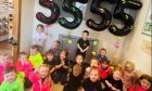 Children sitting in front of balloons