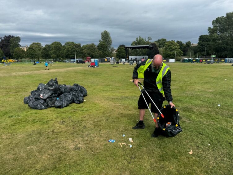 Billy Ritchie picking up litter at Cooper Park in Elgin, after MacMoray.