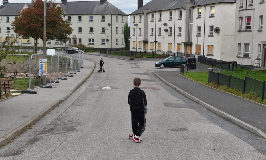 Kids play in the deserted Logie streets as the homes were boarded up for demolition.