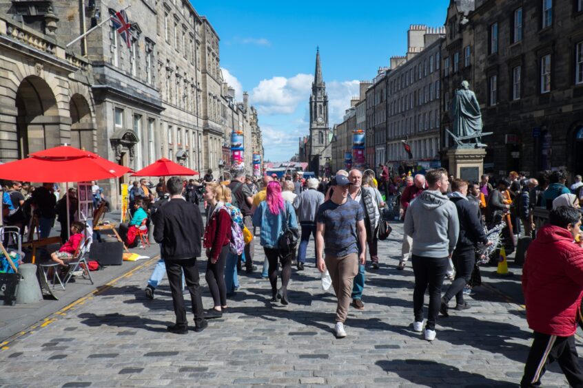 Tourists enjoying entertainment on the Royal Mile during the Edinburgh Fringe Festival. Image: Shutterstock