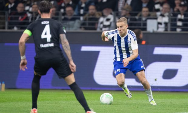 Topi Keskinen runs at Eintracht Frankfurt's Robin Koch for HJK Helsinki in the Europa Conference League at Deutsche Bank Park. Image: Shutterstock.