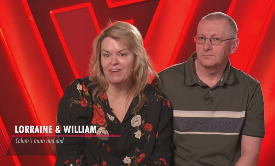 Calum's parents being interviewed in front of a red backdrop.