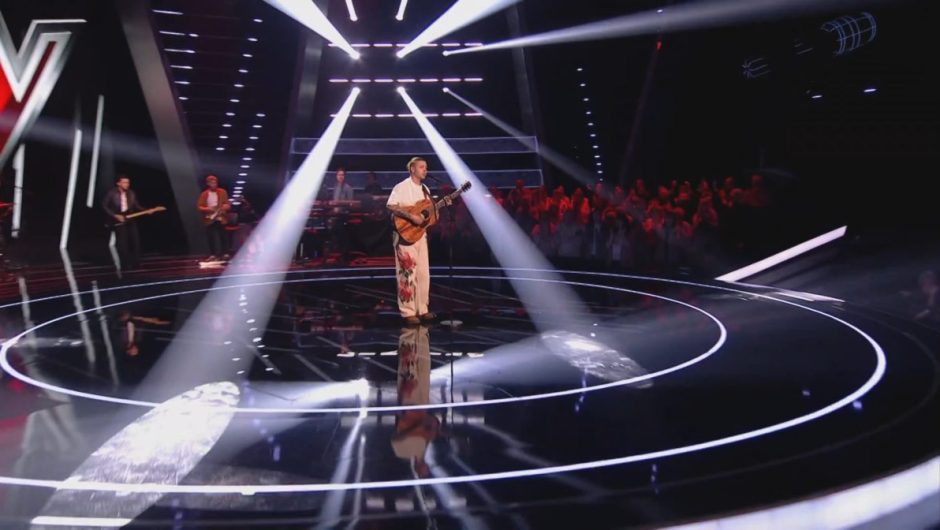 Calum Jones surrounded by strobe lights on stage at the Voice.