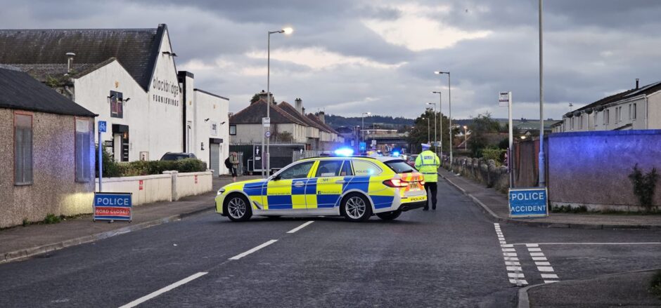 Police can blocks Inverness Street as police officer walks away from vehicle.