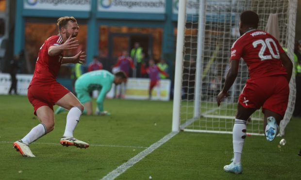 Aberdeen's Nicky Devlin and Aberdeen's Shayden Morris celebrate the late winner scored by Aberdeen's Kevin Nisbet (unseen). Image: Shutterstock.