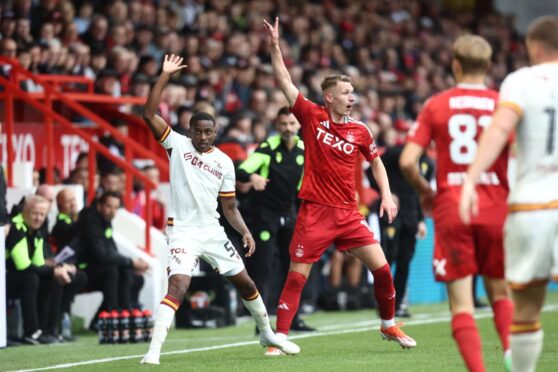 Aberdeen's Pape Gueye, holds off the challenge of Motherwell's Andy Halliday at Pittodrie. Image: SNS