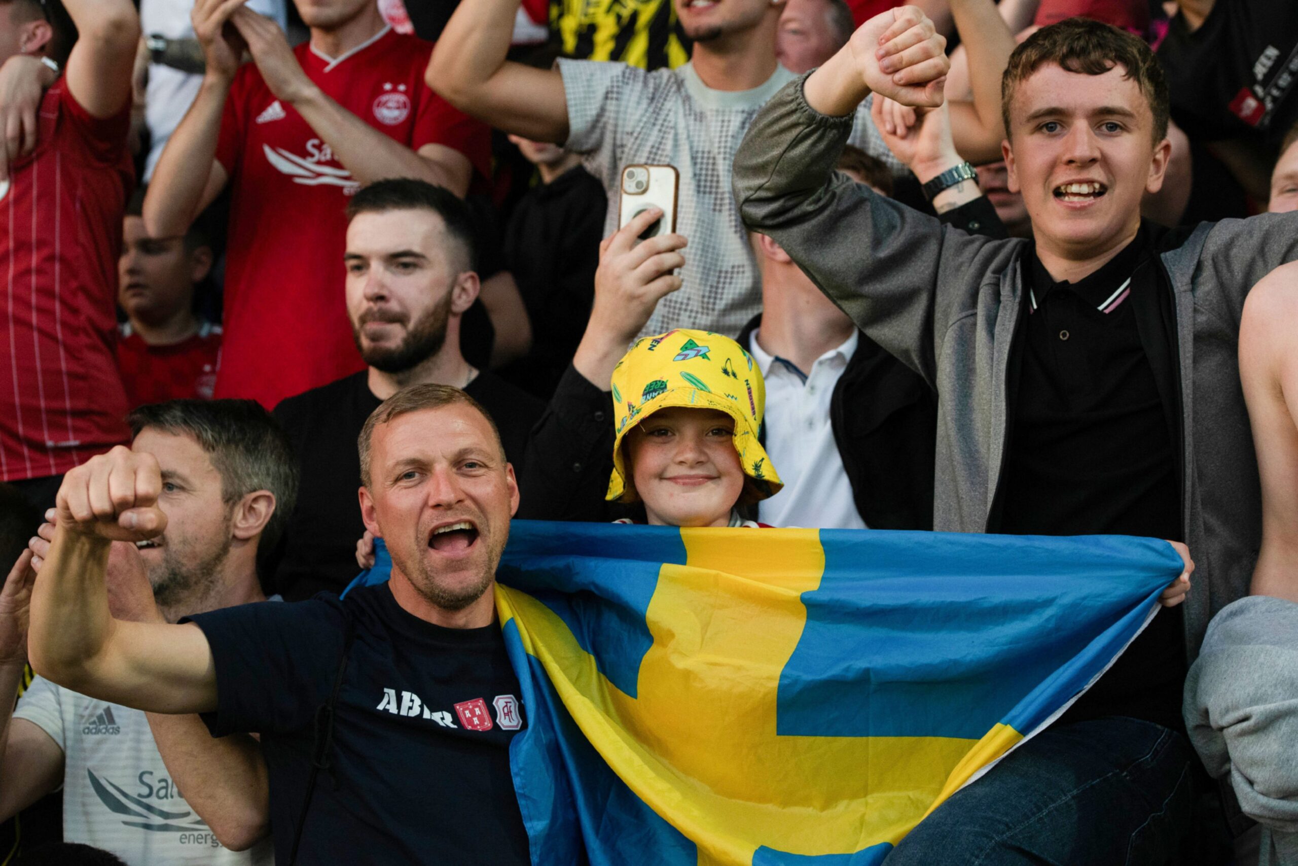 Aberdeen fans celebrate at full time with a Swedish flag after the 1-0 win against Ross County. Image: SNS