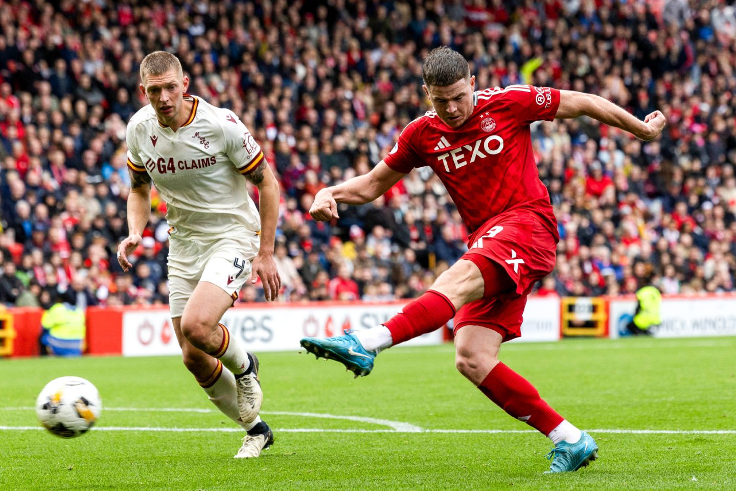 Aberdeen's Kevin Nisbet has a shot as Motherwell's Liam Gordon watches on. Image: SNS 