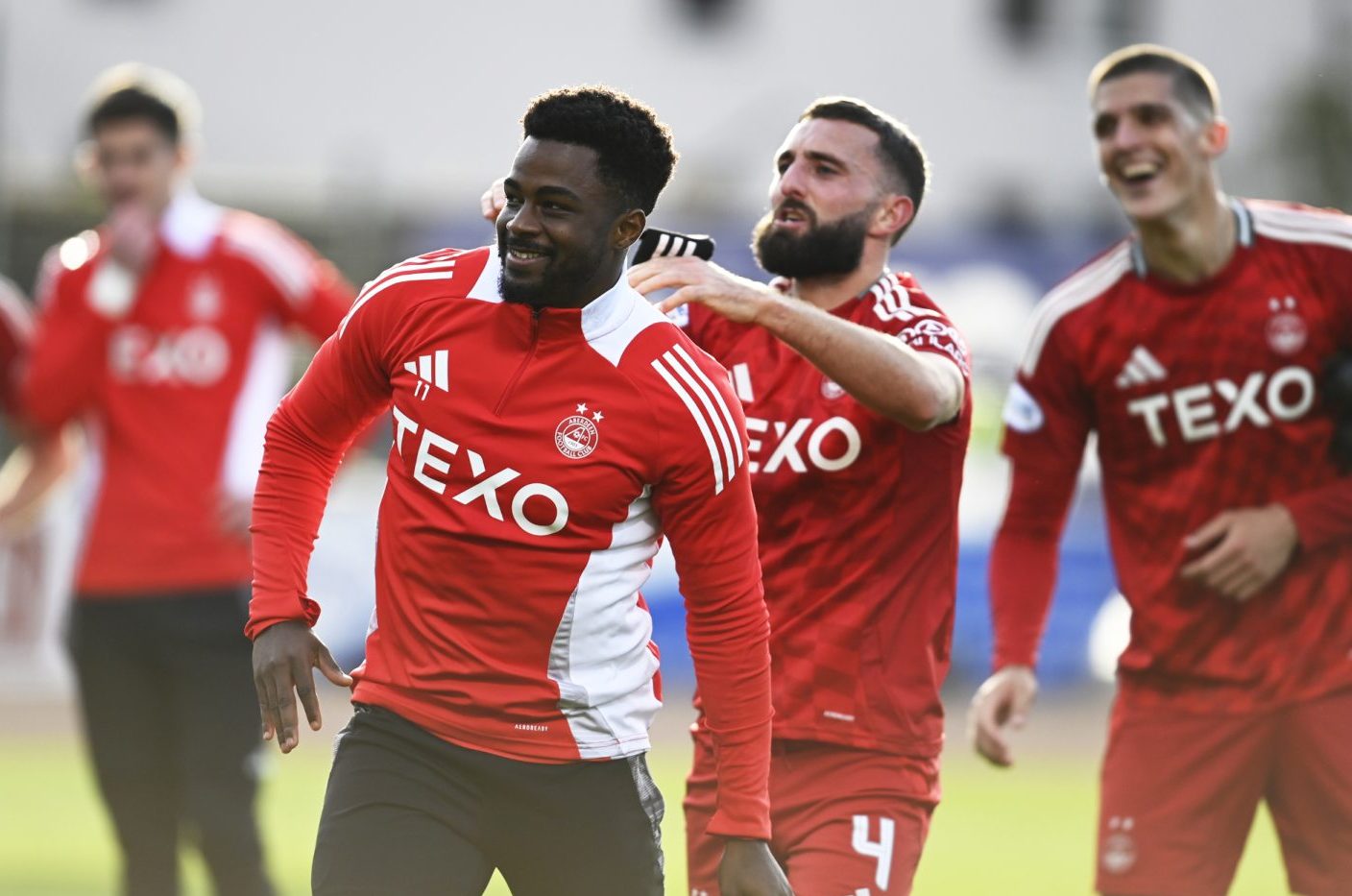 Aberdeen attacker Duk is pushed towards the club's travelling support by captain Graeme Shinnie after the 2=1 win against Dundee. Image: SNS