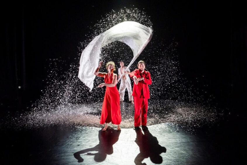 dancers wearing red with a white flag.