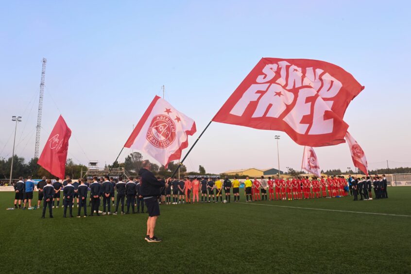 Aberdeen supporters flying the flag on the pitch at Balmoral Stadium. Image Darrell Benns / DC Thomson.