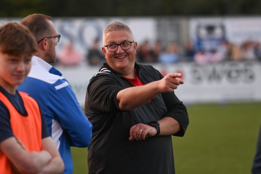 One of the managers in the dugout during the Balmoral Stadium football match. Image: Darrell Benns/DC Thomson