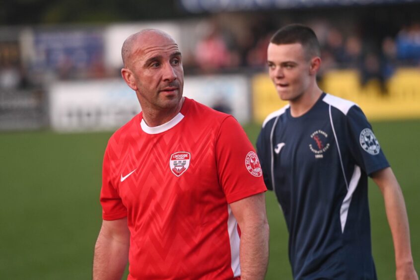 Mike Bradford, Ben's dad, on the pitch with one of the youth squad behind him.