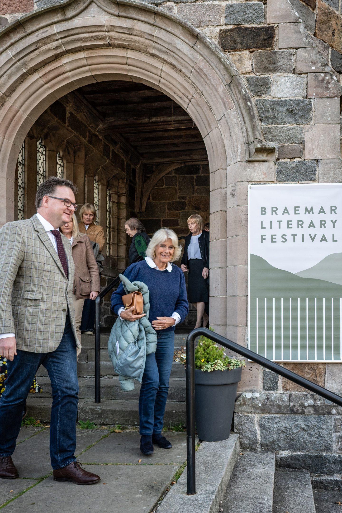 Queen Camilla next to Braemar Literary Festival banner