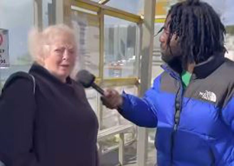 Black Paddy Fabu D interviews a retired woman on the street. 