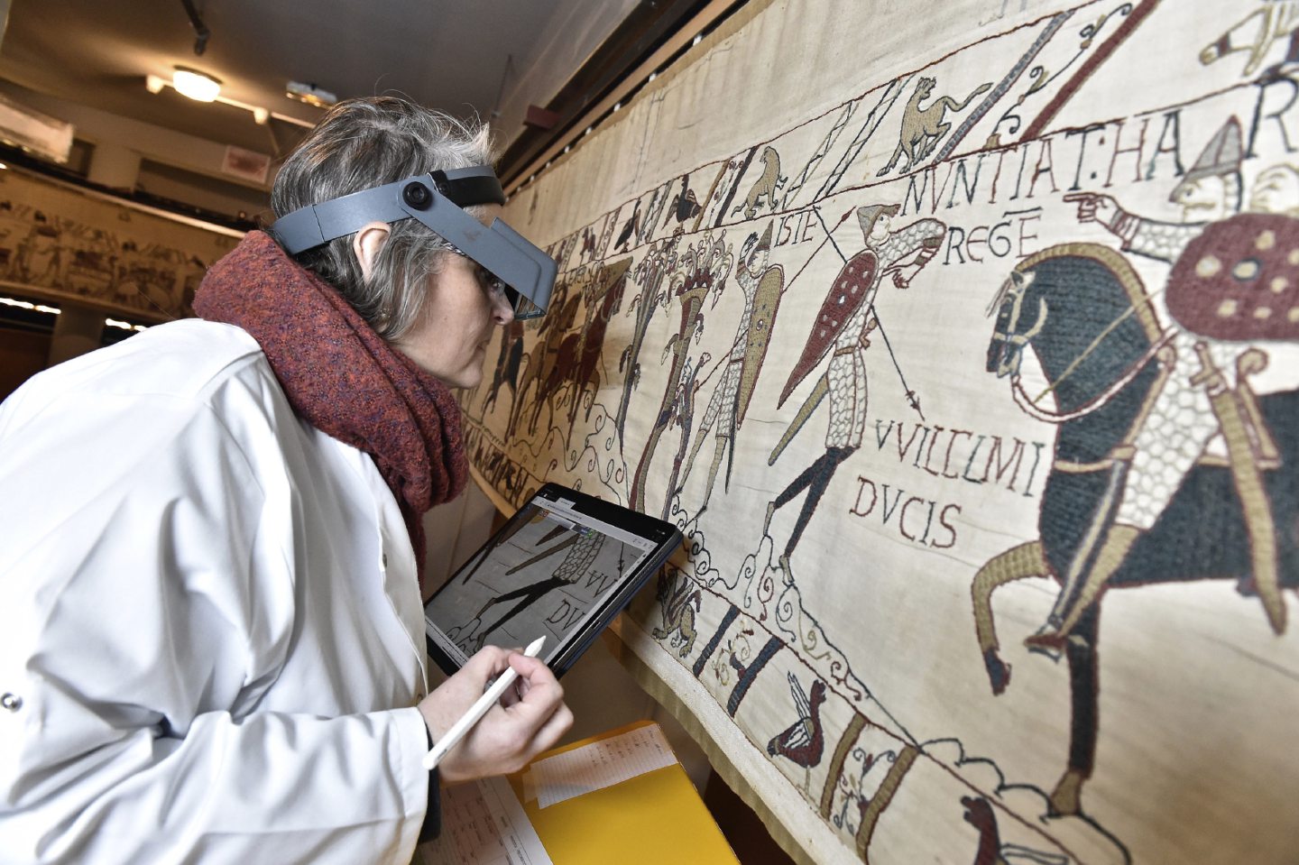 This photo provided by Bayeux townhall shows a technician inspecting the tapestry in Bayeux, Normandy, in Jan. 8 2020. The world-famous Bayeux Tapestry maybe off limits to visitors as the pandemic has shuttered French museums, but its keepers in the small town of Bayeux in Normandy are putting a digital version out online so the public can enjoy its fabled cloth from the safety of home. 