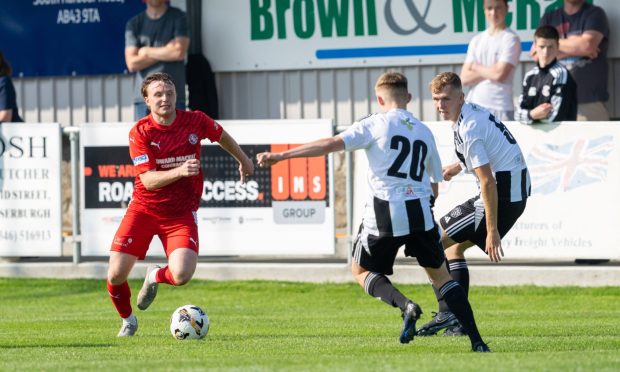 Brora's Tony Dingwall, left, tries to get away from Joshua Hawkins, centre, and Kieran Simpson of Fraserburgh.