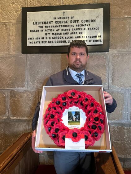 Edward Thomas holding poppy wreath 