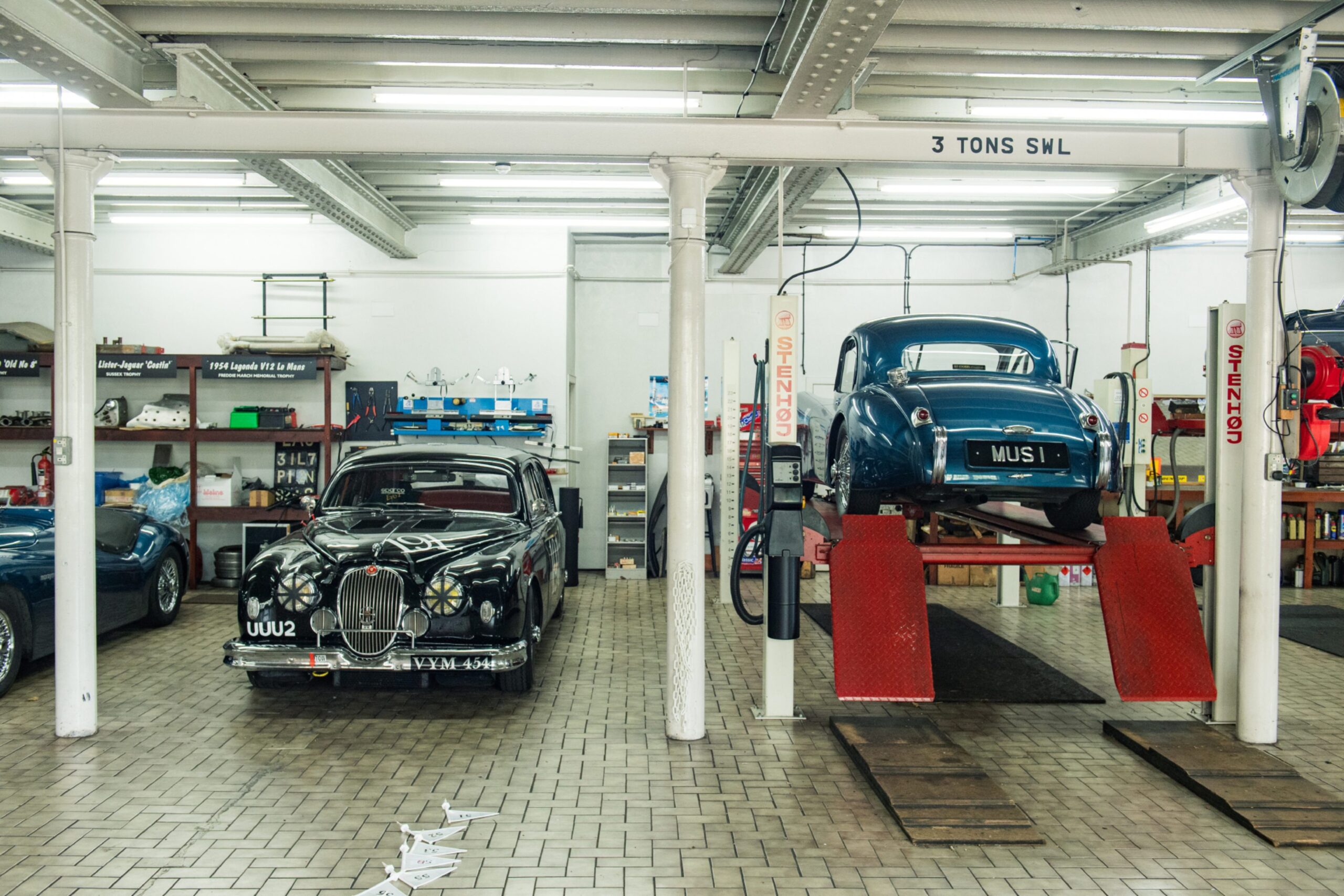 Shiny classic cars including one on a ramp at the Moray Motor Museum.