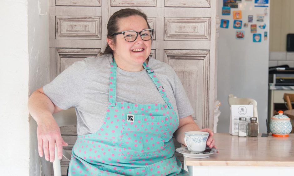 Laura Scott sitting at table with tea cup.