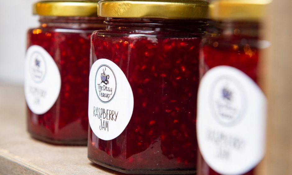 Jars of jam on shelf. 