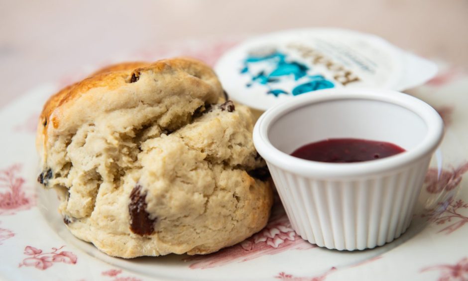 Close-up of scone with jam and cream. 