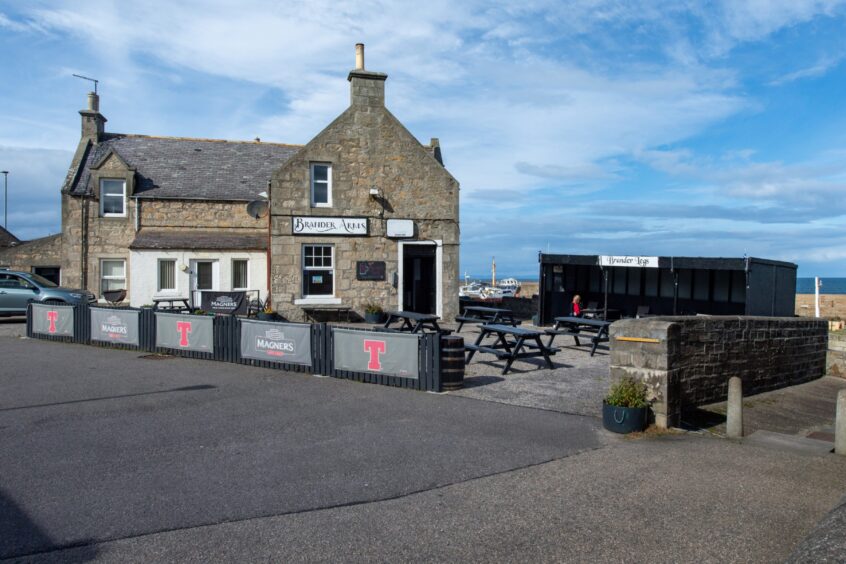 Exterior of Brander Arms pub with outdoor seating 