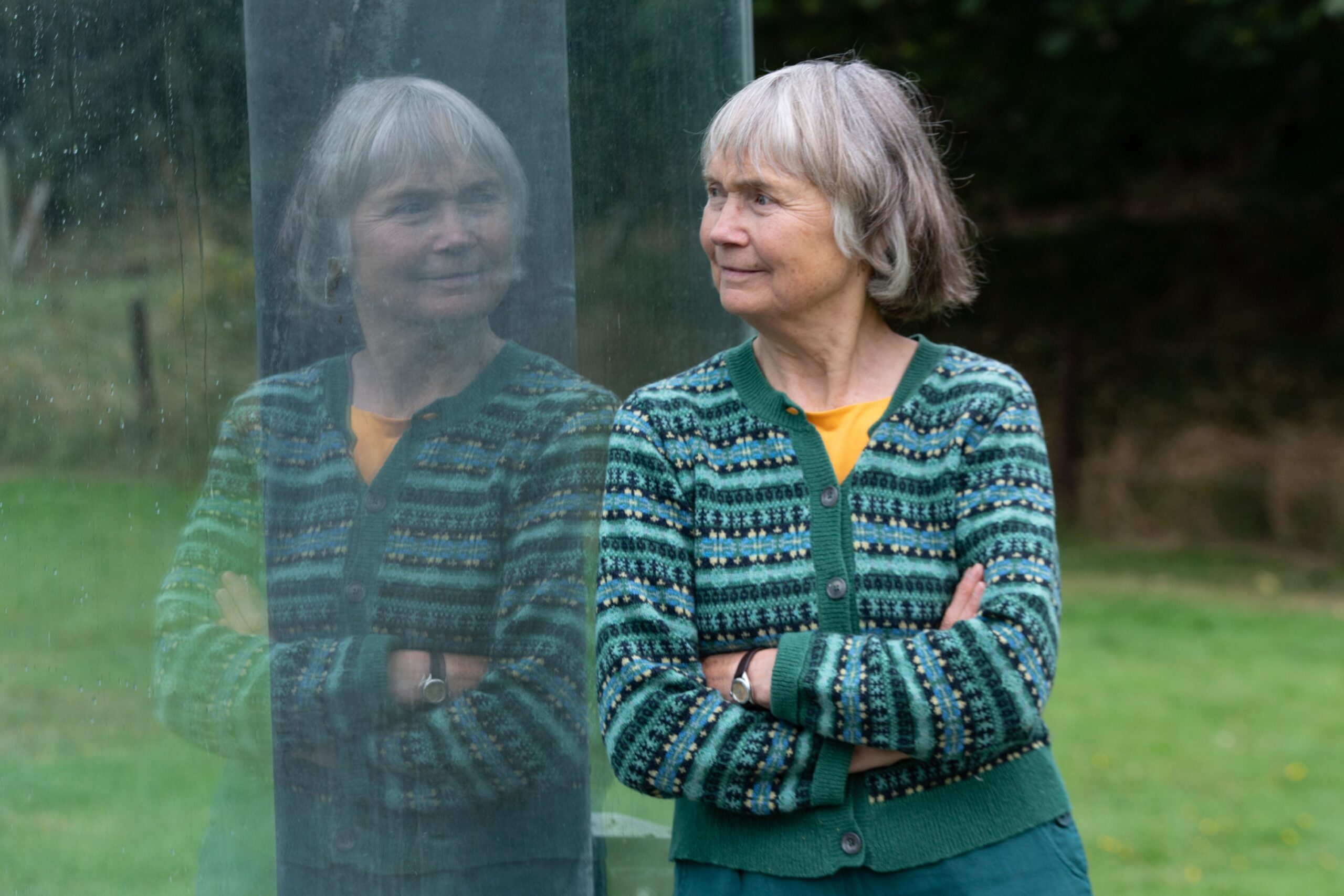 Jane Geddes looking through the glass surrounding the stone. 